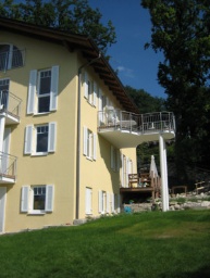 Ansicht Süd, mit Holzterrasse im EG und St.Bt. Balkon mit Holzbelag im OG